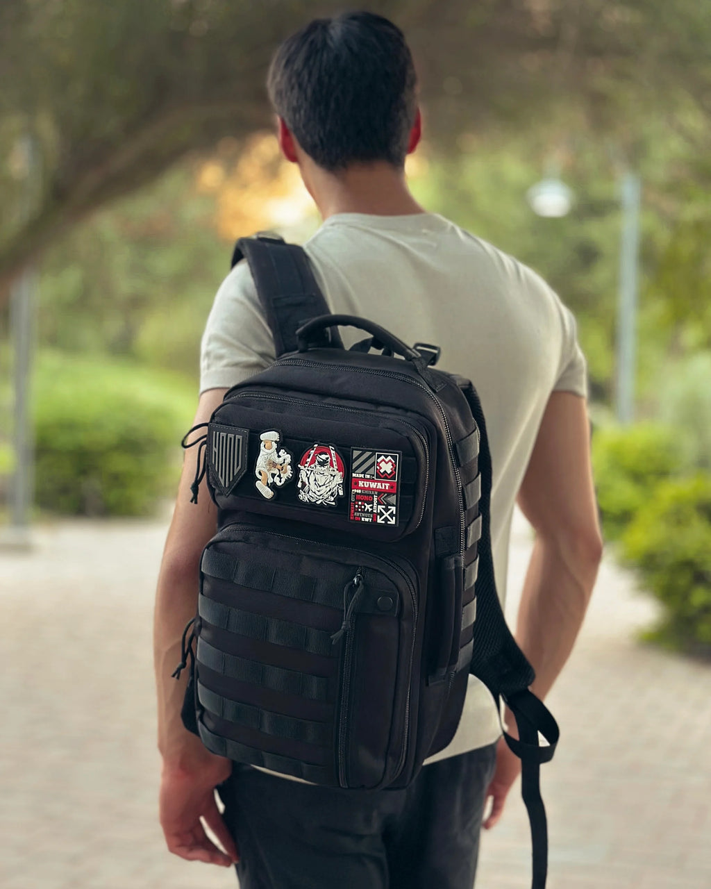 man wearing black tactical backpack 25 L with patches in outdoor life style 