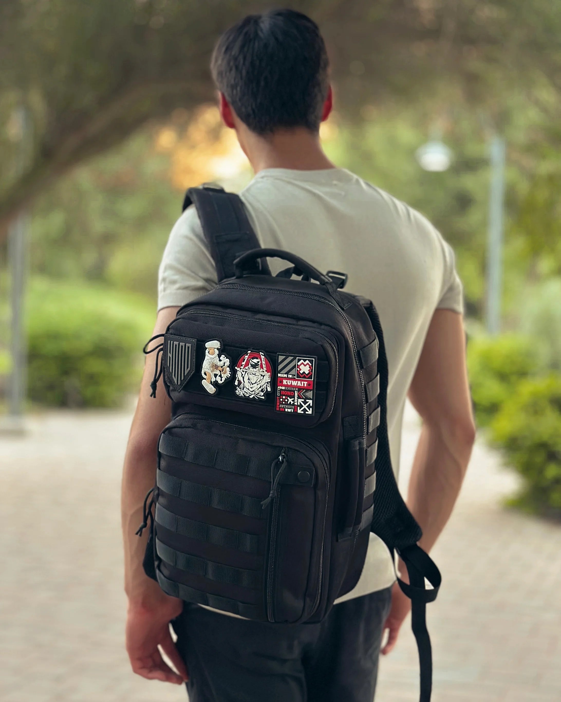 man wearing black tactical backpack 25 L with patches in outdoor life style 