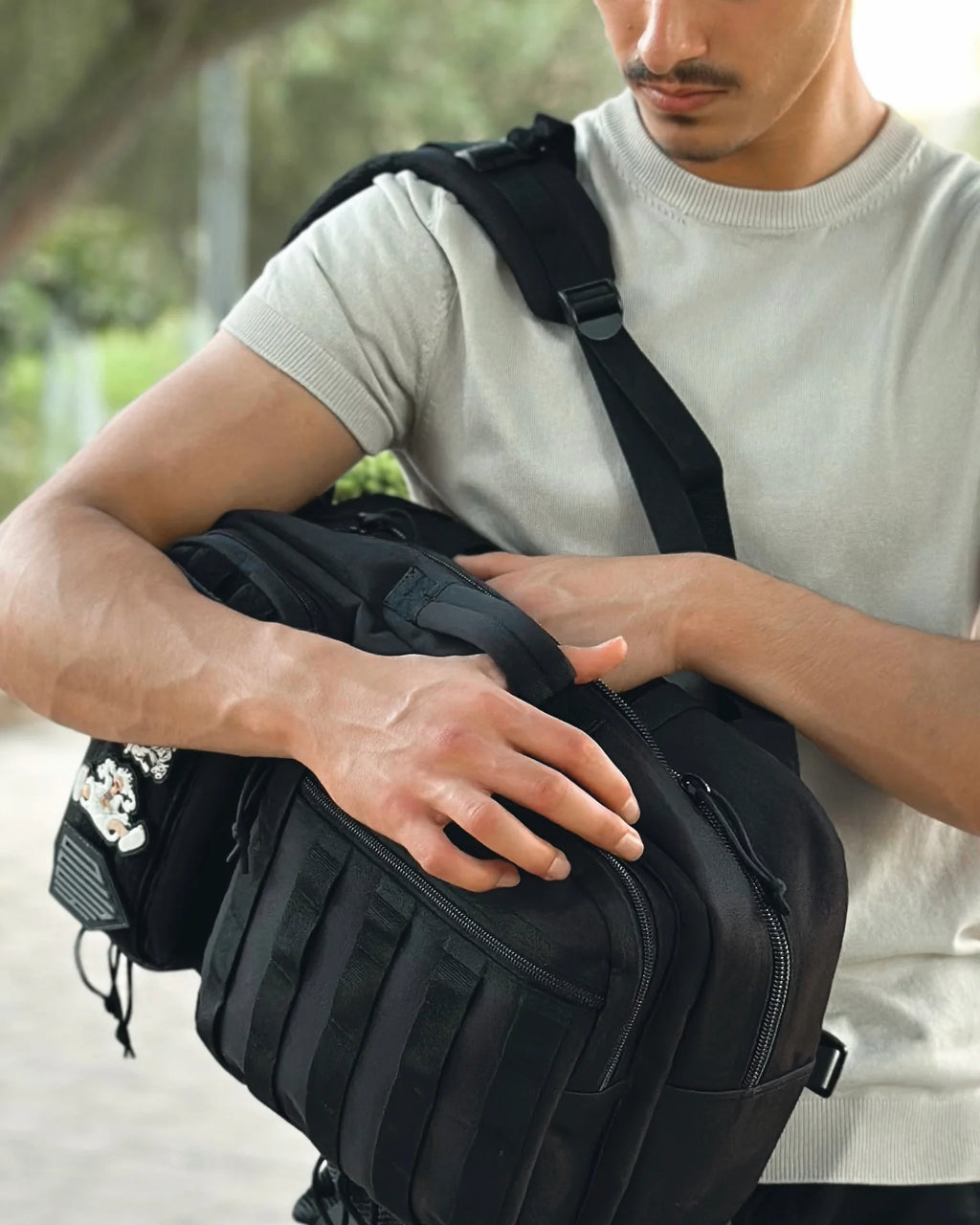 Person holding a black backpack 25 L outdoors